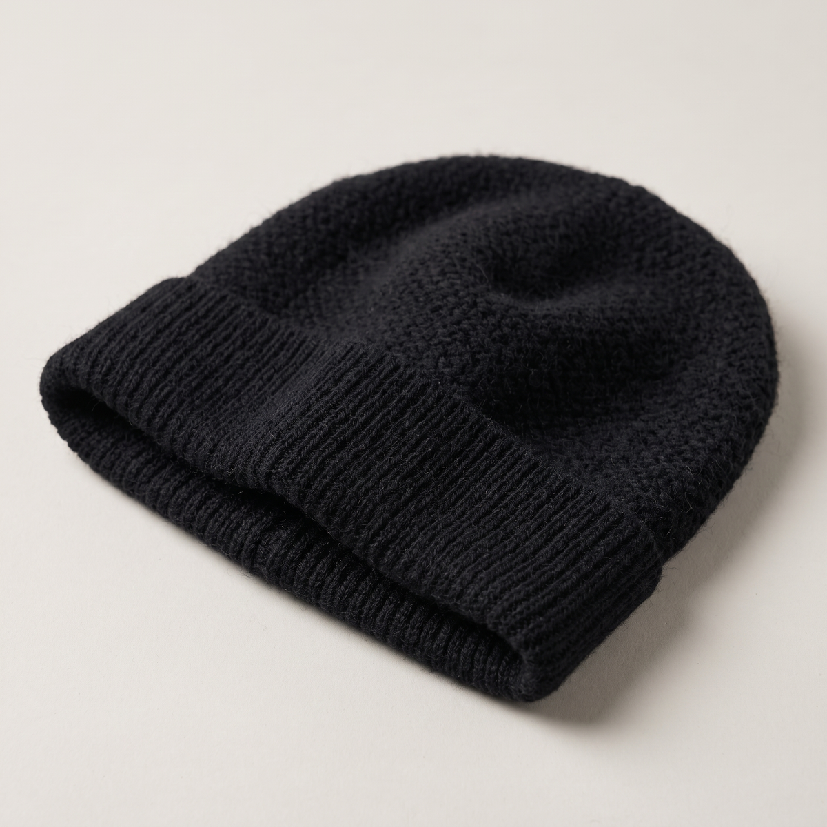 Black wool beanie, close still life showing the knit stitch