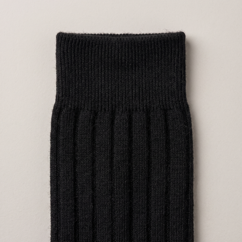 Close-up of the ribbed cuff and fine merino knit, in black