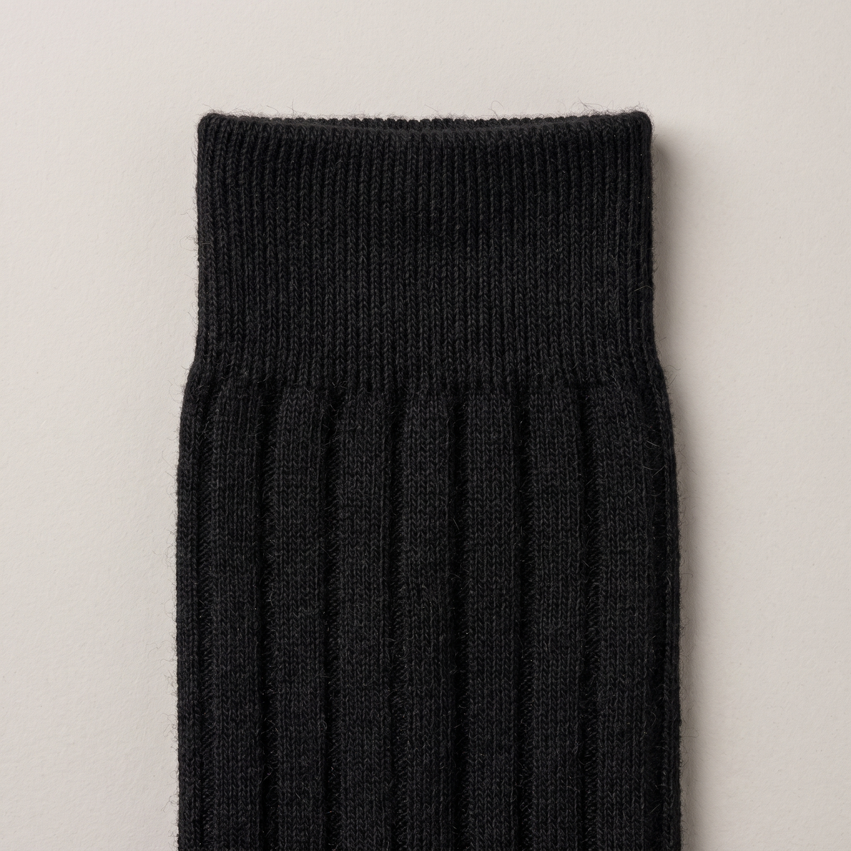 Close-up of the ribbed cuff and fine merino knit, in black